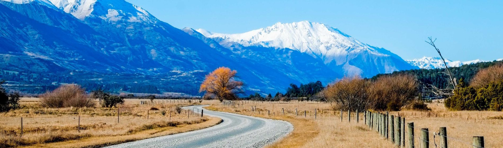 mountain_landscape_with_unsealed_road_and_clear_sky_glenorchy_new_zealand.jpg